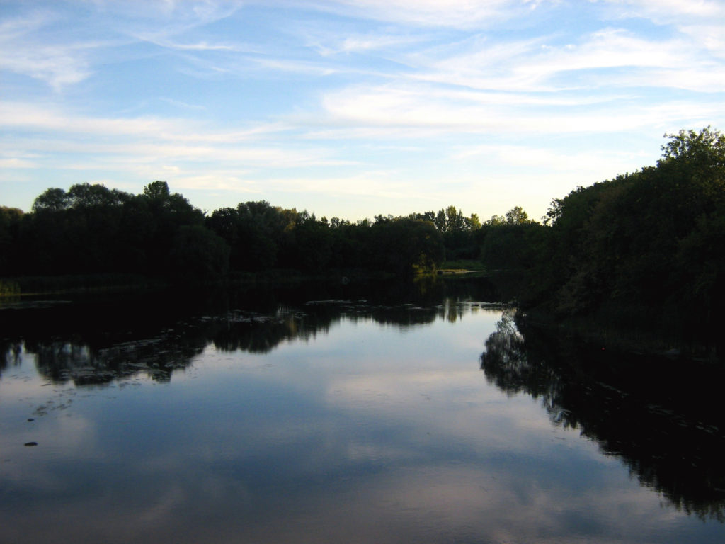 The sky reflects in the waters of the Rideau River.