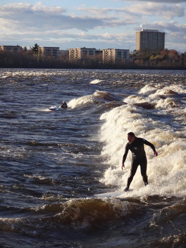 A surfer and a kayaker Ride "The Wave" at Bate Island