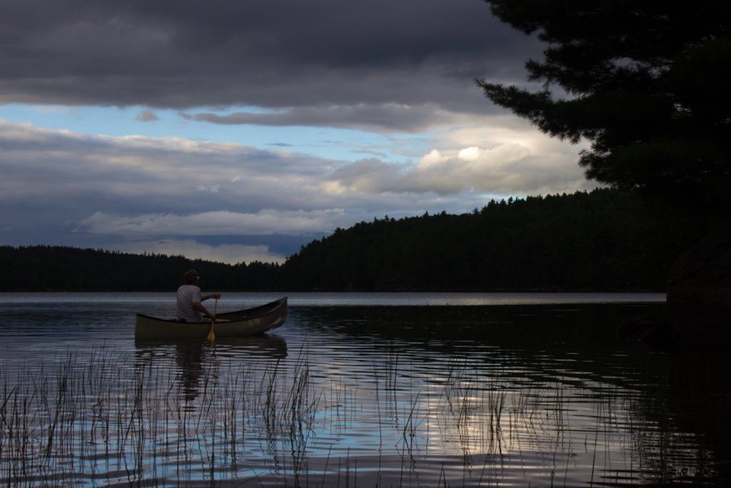 The author paddles his canoe across St. Andrew's Lake in the dusk.