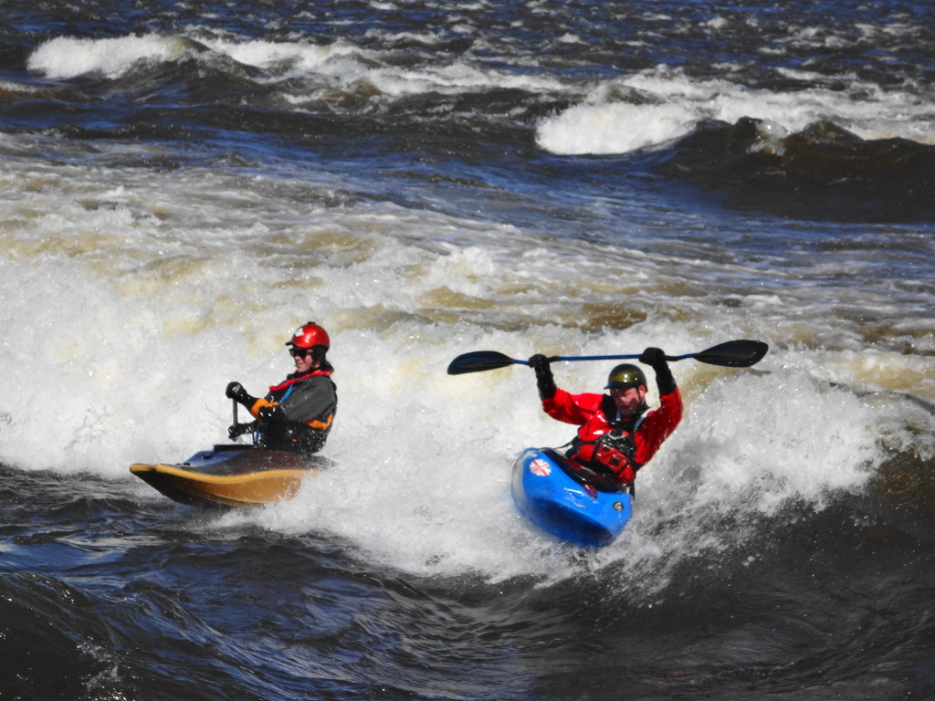 After one of the three kayakers loses his place on "The Wave", the remaining two kayakers perform some tricks.
