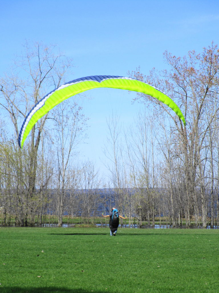 A man flys a parasail on a lawn at Britannia Park as a strong wind blows off the river.