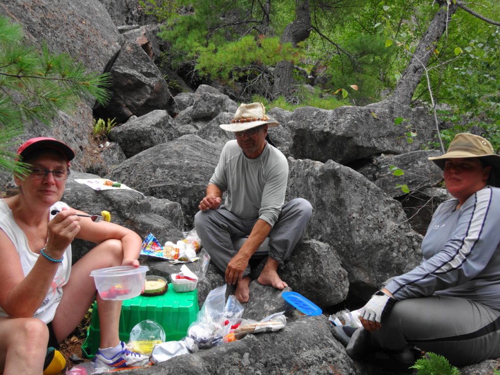 Friends share a lunch on boulders deep in the Barron Canyon.
